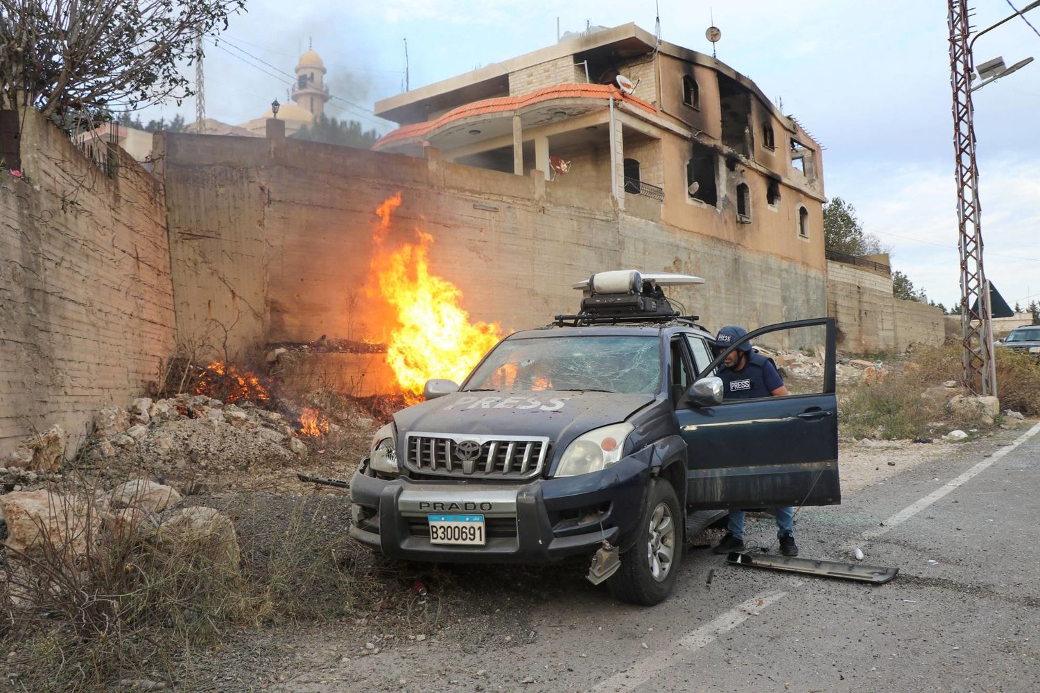 اشتعال النيران قرب سيارة كانت تقل إعلاميين في بلدة يارون بجنوب لبنان نتيجة قصف إسرائيلي (أ.ف.ب)